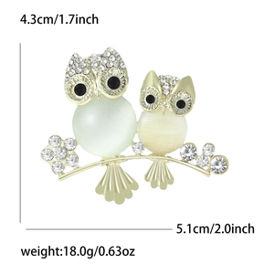 Exquisite owl brooch with opal stones and sparkling rhinestones on a golden branch