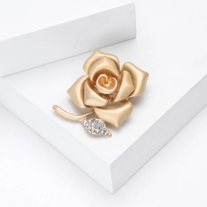 Elegant matte gold rose brooch with sparkling zircon leaf detail on minimalist background