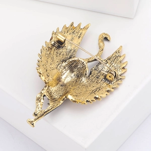 Back view of vintage gold winged cat brooch showing safety pin clasp and brushed texture