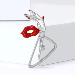 Broche artistique en argent avec lèvres en émail rouge et main sur socle blanc