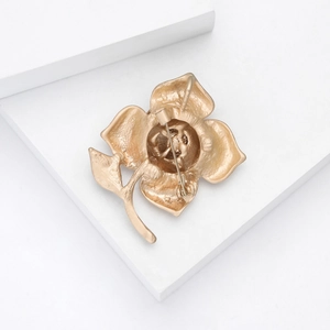 Detailed back view of matte gold rose brooch showing classic safety pin fastener