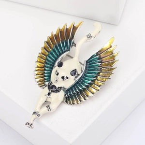 Macro shot of Egyptian cat goddess brooch with enameled wings and vibrant color gradients