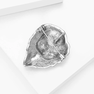 Detailed back view of silver lion brooch showing the secure metal pin closure and texture