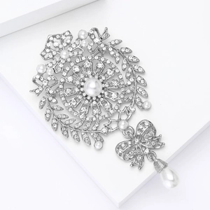 Detail of silver bow brooch with rhinestones, wheat ear patterns and pearl drop pendant