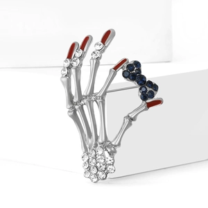 Unique alloy skull hand brooch with blue rhinestone bow and red nail detail