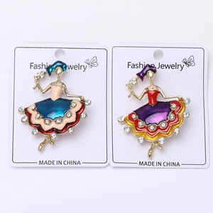 Detailed macro view of enamel ballet girl brooches with crystals on white cardboard