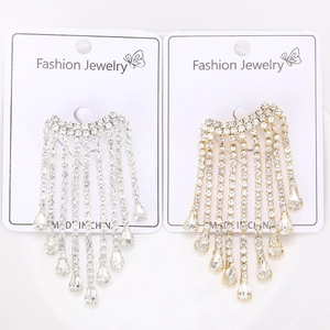 Détail de boucles d'oreilles pampilles dorées et argentées avec gouttes de cristal