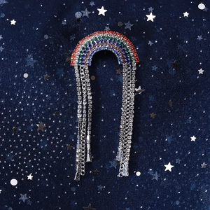 Close-up of rainbow rhinestone brooch featuring silver metal chain tassels and crystals