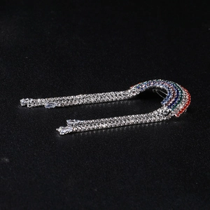 Close-up of rainbow crystal brooch with sparkling rhinestone tassels on black background