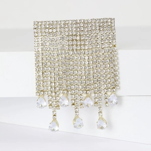 Détail d'une broche en maille strass de luxe avec cristaux en goutte sur présentoir blanc