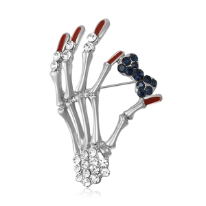 Vintage skull hand brooch with silver finish, sparkling rhinestones and red enamel nails