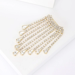 Élégante broche à pompons dorés avec chaînes en strass et gouttes de cristal de poire
