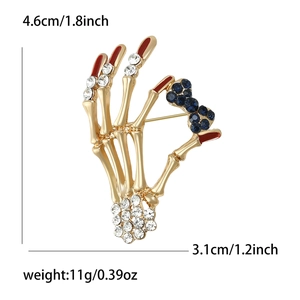 Gothic gold skeleton hand brooch with rhinestones and blue bow, size 4.6cm by 3.1cm