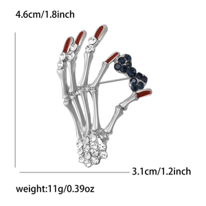 Vintage silver skeleton hand brooch with rhinestones and red drip tip, 4.6cm by 3.1cm