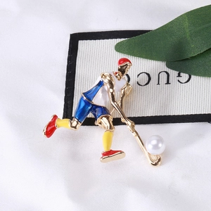 Broche créative de joueur de hockey en émail doré avec perle sur un fond blanc neutre