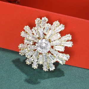 Broche flocon de neige dorée avec cristaux brillants sur une boîte cadeau de fête