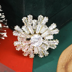 Détail d'une broche flocon de neige en cristal sur un écrin à bijoux festif en velours vert