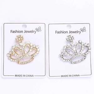 Détails macro des broches couronnes en strass dorées et argentées sur cartes de vente