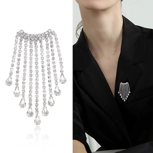 Broche à pompons argentée élégante avec strass brillants et pendentif en cristal