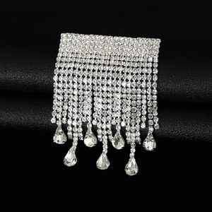 Vue détaillée de la broche argentée avec pompons en strass et cristaux en forme de goutte