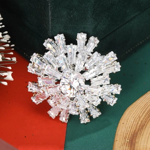 Vue détaillée d'une broche flocon de neige argentée avec zircons sur velours vert