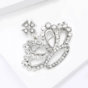 Détail macro d'une broche couronne de luxe en alliage argenté avec strass brillants