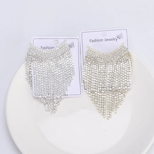 Dettaglio di eleganti orecchini a nappa in oro e argento con strass scintillanti
