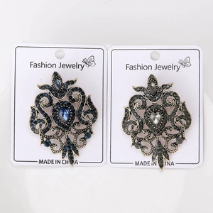 Close-up of vintage hollow baroque brooches with blue and grey crystal rhinestones