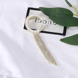 Broche élégante dorée en forme de C avec pompons en cristal et strass baguette brillants