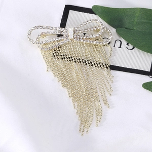 Elegant gold bow brooch with sparkling rhinestones and long bead chain tassels
