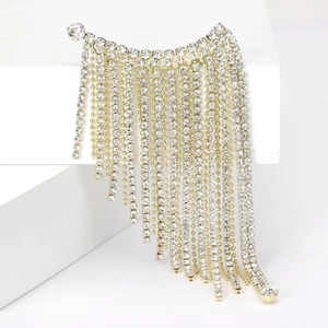 Elegant gold fringe brooch with sparkling rhinestones on a white geometric background