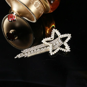 Elegant gold star tassel brooch with rhinestones on a reflective black surface