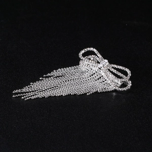 Detail view of silver bow brooch with tassels and sparkling micro-pave zirconia stones