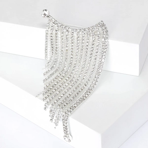 Detailed macro view of silver tassel brooch with rhinestones on a white pedestal