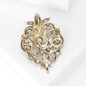 Detailed back view of vintage baroque brooch featuring gold filigree and safety pin clasp