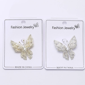 Détail de broches papillon scintillantes avec incrustations de zircon en argent et or