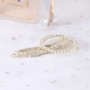 Broche pompon en strass doré avec design circulaire et détails de franges scintillantes