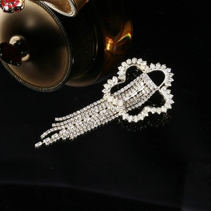 Broche fleur argentée élégante avec glands en strass pendants sur fond noir raffiné