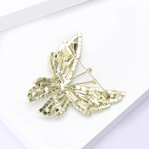 Détail du fermoir de sécurité et de la structure arrière dorée de la broche papillon