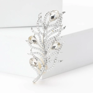 Macro shot of silver feather brooch with small white pearls and water drop diamonds
