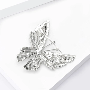 Vue détaillée de la broche papillon argentée avec des strass étincelants sur les ailes