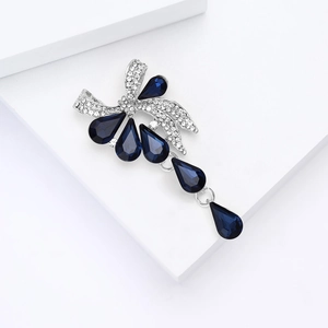 Détail de la broche nœud en cristal de luxe avec strass bleus en forme de gouttelette