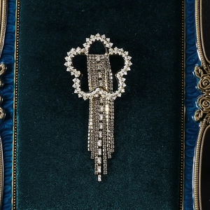 Détail d'une broche en étoile scintillante avec de longs glands en strass sur velours