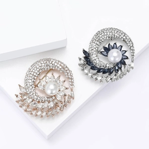 Elegant rhinestone brooch with large central pearl in gold and silver finishes