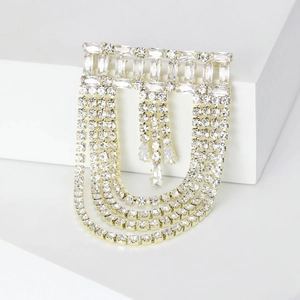 Detailed macro view of gold-plated tassel brooch with multi-layer baguette-cut crystals