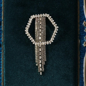 Macro shot of silver rhinestone tassel brooch showing detailed sparkling crystals and fringe