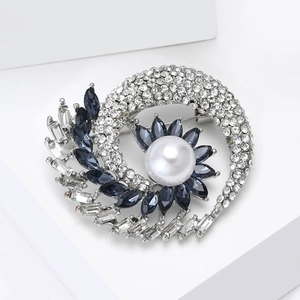 Elegant spiral floral brooch with white pearl, blue gems, and sparkling diamonds
