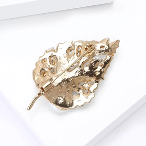 Vue arrière détaillée de la broche feuille montrant le fermoir et la texture en métal évidé