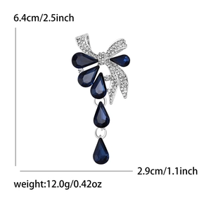 Broche nœud élégante en argent avec cristaux en goutte bleus et strass brillants