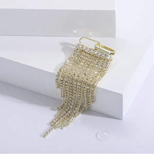 Elegant gold rhinestone tassel brooch with flowing crystal chains on white pedestal